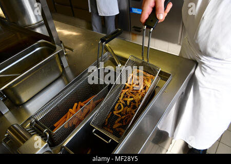 Archiviato - 08 marzo 2018, Germania, Brema e Bremerhaven: Dominik Flettner, capo chef dell'Atlantic Hotel Sail City, sorge nella sua cucina preparazione potatoe fries. Flettner è consapevole di produrre come littell rifiuti come possibile nella sua cucina e utilizza potatoe bucce, ad esempio per friggere deliziosa potatoe chips come insalata sidedish. Egli è un membro del " Regno contro rifiuti" campagna. Foto: Karsten Klama/dpa Foto Stock