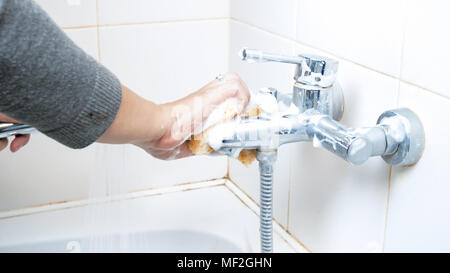 Primo piano della giovane donna bagno di lavaggio rubinetto di acqua con detersivo e spugna Foto Stock