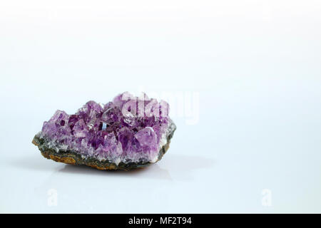 Isolato preziosa gemma ametista con sfondo bianco. Si tratta di un viola / viola varietà di quarzo spesso usato in gioielleria. Foto Stock