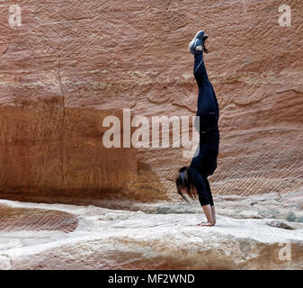 Petra Wadi Musa, Giordania, 9 Marzo 2018: Close-up di una giovane ragazza europea alla formazione un handstand nel Siq di Petra, medio oriente Foto Stock