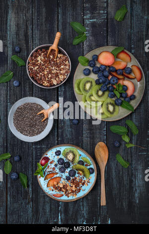 Frullato di super bowl con semi di Chia, mirtilli e pesche noci, kiwi e cioccolato granola Foto Stock