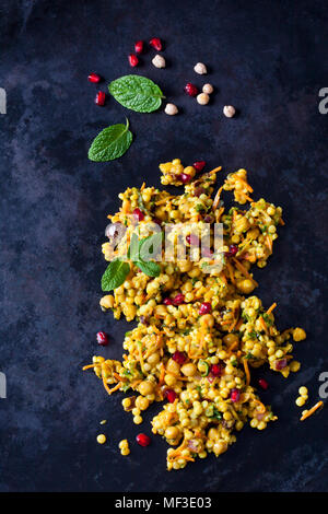 Il cous cous insalata con ceci e mirtilli rossi sulla terra scura Foto Stock