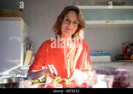 Ritratto di donna fare confettura di fragole in cucina a casa Foto Stock