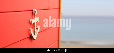 Elemento di ancoraggio sulla rossa di età compresa tra superficie. Sfocato, vuoto spiaggia sabbiosa, blu cielo, mare sullo sfondo. Spazio per il testo, banner, vista ravvicinata. Foto Stock