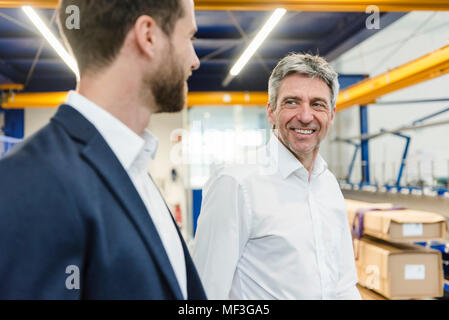 Uomini d'affari durante la riunione nella sala di produzione Foto Stock