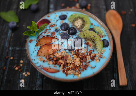 Frullato di super bowl con semi di Chia, mirtilli e pesche noci, kiwi e cioccolato granola Foto Stock