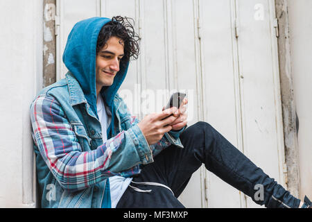 Giovane uomo utilizza lo smartphone Foto Stock