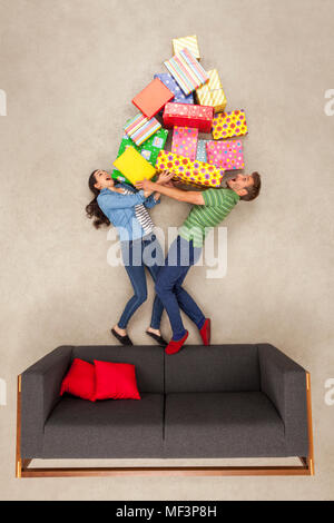 Matura in piedi sul lettino, azienda grande pila di regali Foto Stock