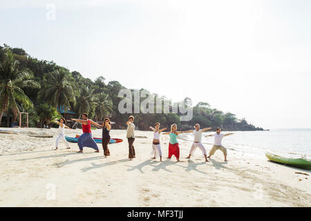 Thailandia Koh Phangan, gruppo di persone a praticare lo yoga su una spiaggia Foto Stock
