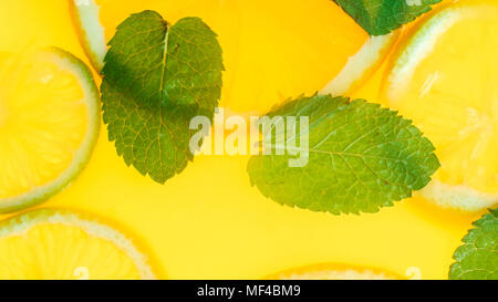 Primo piano immagine di colore arancione con limonata fresca di tagliare a fette e e le foglie di menta Foto Stock