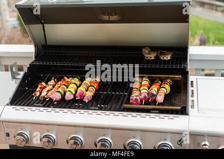 Passo dopo passo. Grigliare gli spiedini di verdure e spiedini di pollo su outdoor grill a gas. Foto Stock