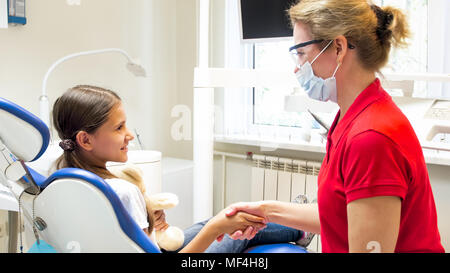 Ritratto di Dentista pediatrico scuotendo le ragazze mano dopo il trattamento di denti Foto Stock