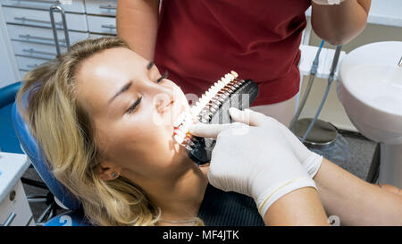 Primo piano immagine del dentista pazienti di corrispondenza del colore dei denti con speciali checker Foto Stock