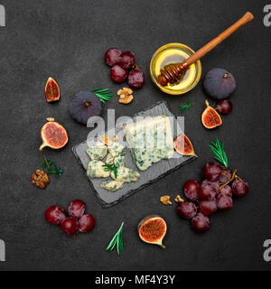 Fetta di Francese Roquefort formaggio e frutta sulla scheda di pietra Foto Stock