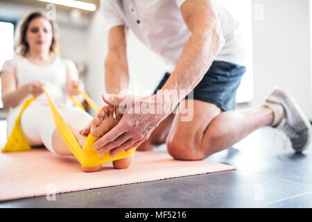 Irriconoscibile senior fisioterapista lavora con un paziente femmina. Foto Stock