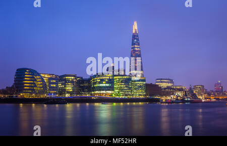 Londra, Inghilterra - Vista Panoramica di Belfast cruiser ship e illuminato in uffici di Londra con Shard grattacielo a sfondo blu a ora Foto Stock
