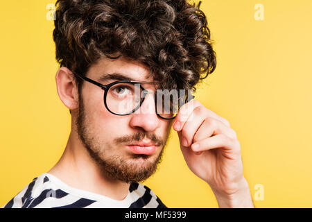 Studio ritratto di un giovane uomo di uno sfondo giallo. Foto Stock