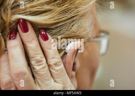 Close-up di donna senior con apparecchi acustici Foto Stock