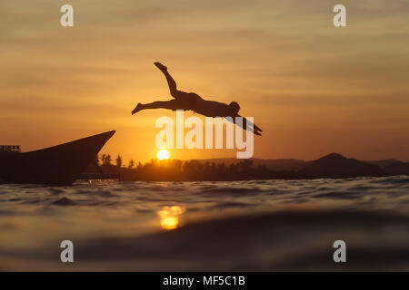 Indonesia, Lombok, uomo saltando in acqua Foto Stock