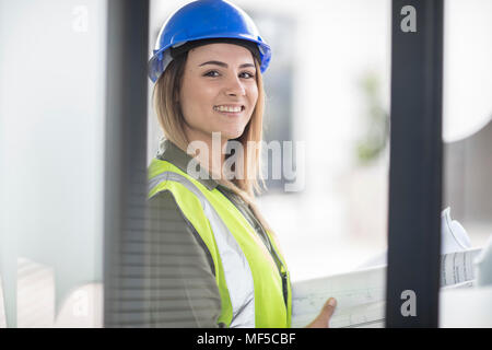 Ritratto di donna sorridente indossare elmetto e giubbotto riflettenti Foto Stock
