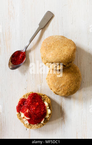 Focaccine fatte di grano farro piccolo con confettura di fragole e clotted cream Foto Stock