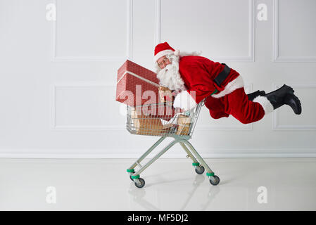 Babbo Natale che porta i regali di Natale con carrello Foto Stock