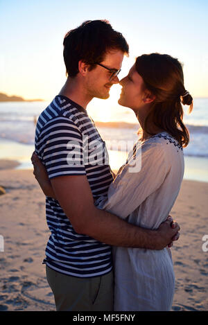 Coppia romantica sulla spiaggia al tramonto Foto Stock