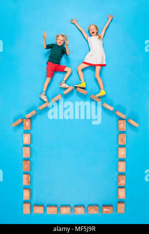 Fratello e Sorella ballando sul tetto della propria casa Foto Stock