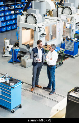 Uomini d'affari durante la riunione nella sala di produzione Foto Stock