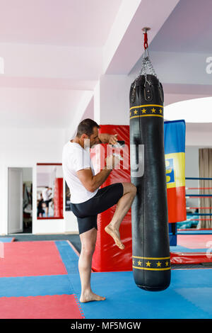 Kickbox fighter training in una palestra con punzone sacchetti, vedere tutta la serie Foto Stock