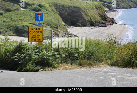 Strada chiusa a causa di erosione costiera a pendower spiaggia a sud della costa di Cornovaglia Foto Stock