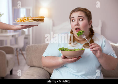 Stout rosso testa di donna di decidere quale tipo di cibo da scegliere Foto Stock