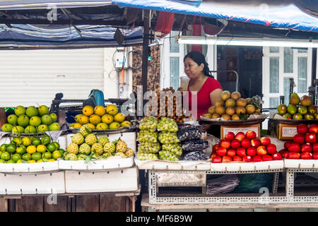 Una femmina di titolare di stallo di bere una bevanda in lei la frutta e la verdura in stallo il Ton diga che i mercati di strada, Ho Chi Minh City, Vietnam. Foto Stock