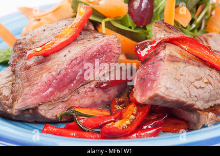 Un bavette o fianco, bistecca di manzo ha acquistato da un supermercato nel Regno Unito. Servita con patatine fritte peperoni rossi e una frutta mista, rucola e insalata di noce con slic Foto Stock