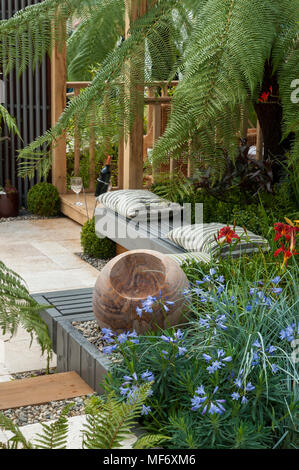 Palme esotiche, gazebo, ornamento di pietra e fiori in stile tropicale giardino mostra - Visita Plantation: Colonial chic e Bajan radici. RHS mostrano Tatton Park. Foto Stock