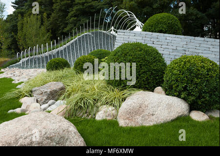 Drammatica scultura di metallo, pietre bianche, erbe & buxus rappresentano le onde & litorale - 'Wave Dance' giardino, RHS Flower Show, Tatton Park, Inghilterra, Regno Unito. Foto Stock