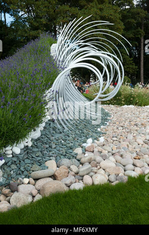 Drammatica scultura di metallo, ciottoli bianchi & pietre rappresentano le onde che si infrangono sulla battigia in 'Wave Dance' garden - RHS Flower Show, Tatton Park, England, Regno Unito Foto Stock