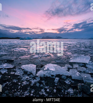 Colorato tramonto Immagine di Jokulsarlon laguna glaciale in Islanda con dei pezzi di ghiaccio e montagne Foto Stock