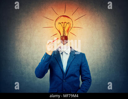 Immagine surreale come un imprenditore con volto invisibile tenendo una matita in mano disegnare lampadina incandescente, come idea e simbolo di ispirazione. Lampadina instea Foto Stock