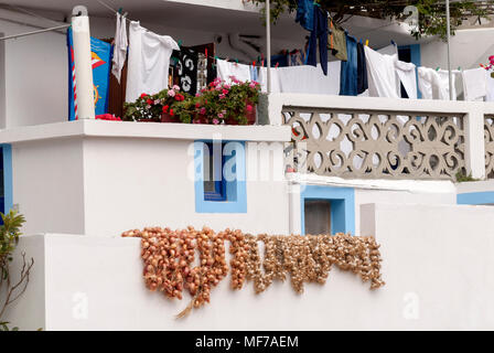 Grecia Isole dell' Egeo, isola di Karpathos, Olympos : raccolto di cipolle e la biancheria viene essiccato su un balcone di una casa tradizionale Foto Stock