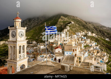 Grecia Isole dell' Egeo, Olympos, Karpathos isola, la chiesa e la parte superiore del villaggio con il mulino a vento in rovina Foto Stock