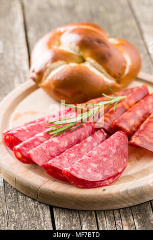 Fette di salame affumicato insaccato su tagliere. Foto Stock