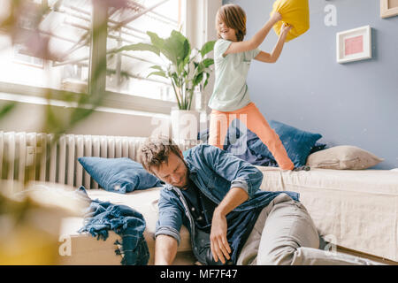 Padre e figlio avente un cuscino lotta in casa Foto Stock