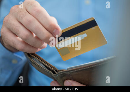 Uomo di mani tenendo la carta di credito e portamonete, close-up Foto Stock