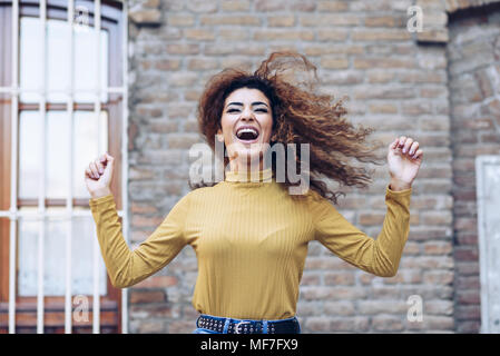 Spagna, Andalusia, Granada. Bella giovane donna con parentesi di acconciatura di capelli in movimento all'esterno. Il concetto di stile di vita Foto Stock