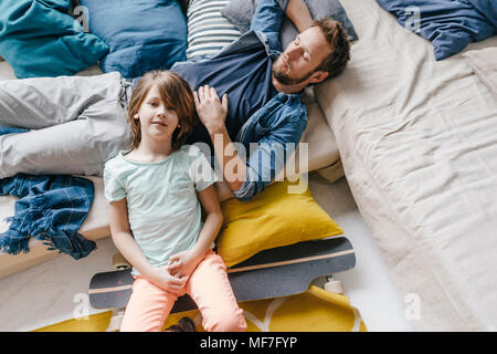 Padre e Figlio con lo skateboard in un momento di relax a casa Foto Stock