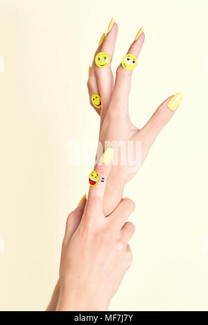 Close-up di donna con le mani emojis sugli anelli Foto Stock