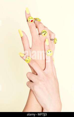 Close-up di donna con le mani emojis sugli anelli Foto Stock
