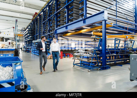Uomini d'affari durante la riunione nella sala di produzione Foto Stock