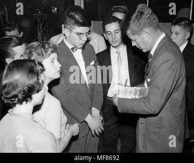 PC780 c.1956-1957 Senatore John Fitzgerald Kennedy segni una copia di 'Profili in coraggio" per un giovane fan. Fotografo sconosciuto in John F. Kennedy Presidential Library and Museum di Boston. Foto Stock